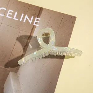 Detail of mint green iridescent shark clip featuring a glossy twist design and golden spring