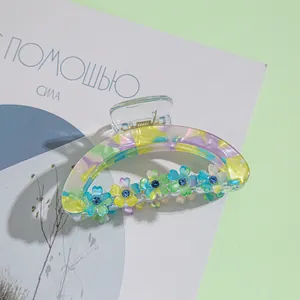 Λεπτομέρεια από κλαμερ μαλλιών με μαρμάρινη υφή και λουλούδια διακοσμημένα με στρας
