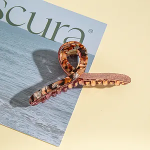 Close-up of large acrylic hair claw clip with tortoise shell and rose gold glitter finish
