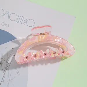 Détail de la pince à cheveux en acrylique rose marbré avec papillons en strass