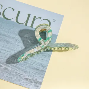 Detail of light green marble acrylic hair claw clip with sparkling glitter and gold spring