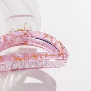 Pink marble texture hair claw clip with gold glitter accents and metal spring detail