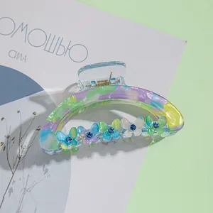 Vue détaillée d'une pince à cheveux en acrylique marbré avec des papillons colorés