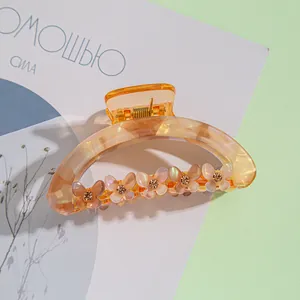 Détails d'une pince à cheveux ambre avec des papillons ornés de strass brillants