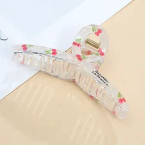 Detail of 11cm clear acrylic hair claw clip with cherry pattern and gold metal spring