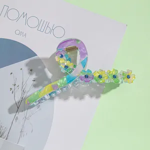 Détail d'une grande pince à cheveux en acétate avec motif marbré et strass floraux