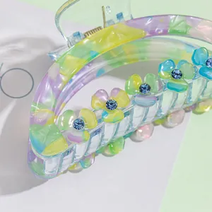 Floral 9cm acrylic hair claw clip with blue rhinestone flowers and marbled design