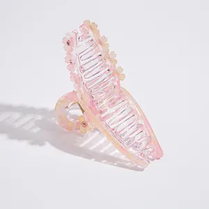 Détail d'une pince à cheveux rose en acétate ornée de fleurs et de cristaux brillants