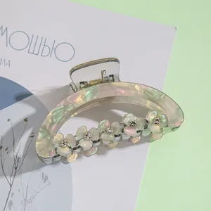 Detailed macro view of pearlescent flower hair claw clip with crystal rhinestones