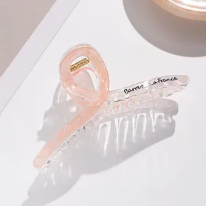 Dettaglio di un fermaglio per capelli da 13cm in acrilico rosa marmorizzato con molla dorata