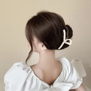 Pince à cheveux minimaliste crème à motif damier sur une coiffure relevée élégante