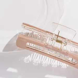 Elegant large pink and clear acrylic hair claw clip for thick hair shown on a glass tray