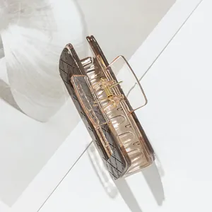 Detail of coffee-colored claw clip with lattice pattern and strong metal spring