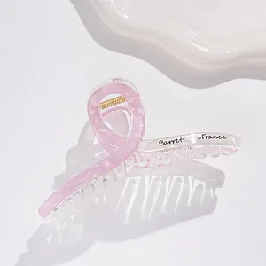 Dettaglio molletta per capelli rosa perlato con molla dorata e scritta Barrette France