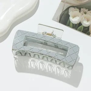 Detail of grey diamond pattern hair claw clip with modern matte finish and metal spring