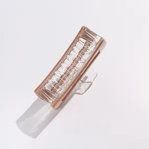 Close-up of large acrylic hair claw clip showing clear and beige dual-tone design