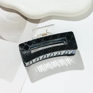 Close-up of black quilted pattern hair claw clip with rectangular hollow out design