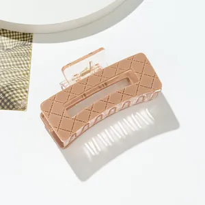 Detailed view of the checkered pattern on a small acrylic hair claw with gold spring