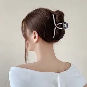 Large acetate hair claw clip in smoky grey with pink accents on brunette hair