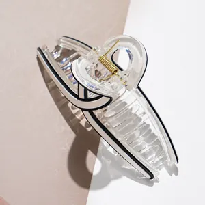 Large acetate hair claw clip with geometric black and white patterns for daily hair styling