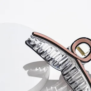 Detailed macro view of an acetate hair claw clip with golden spring and black trim