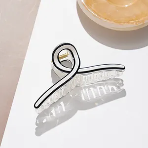 Detail view of large acetate hair claw clip with black and white geometric patterns