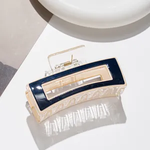 Détail d'une pince à cheveux rectangulaire en acétate bleu marine et beige avec ressort doré