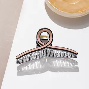Detail of large acetate hair claw clip showing translucent teeth and gold metal spring