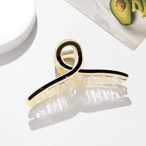 Detailed view of large cream acetate hair claw clip with black outlines and metal spring