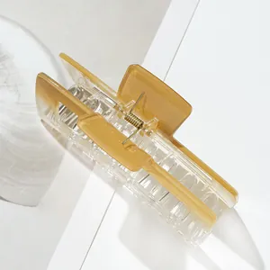 Close-up of large amber gradient resin hair claw clip with golden metal spring