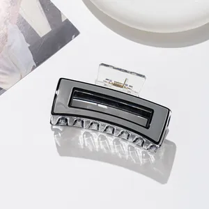 Vue détaillée d'une grande pince à cheveux rectangulaire noire et blanche en acétate