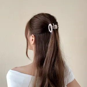 Pinza per capelli ovale opaca color crema dal design minimalista su un semi-raccolto
