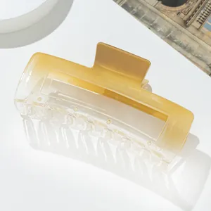 Close-up of translucent yellow gradient rectangular claw clip with non-slip hair teeth