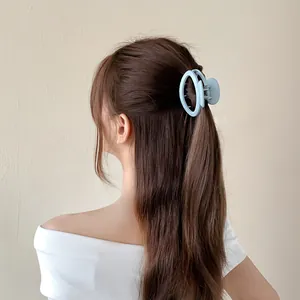 Matte light blue oval hair claw clip shown from back view on long brown hair