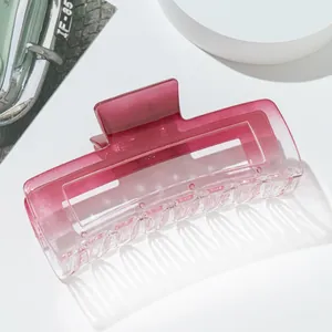 Detail view of large matte pink gradient rectangle hair claw clip on white platform