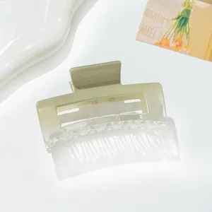 Close-up of square hollowed hair claw clip in matte gradient avocado green resin