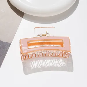 Vue détaillée d'une pince à cheveux rectangulaire rose avec un cadre transparent moderne