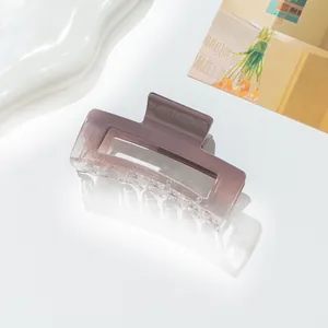 Close-up of rectangular purple gradient acrylic hair claw clip on a decorative tray