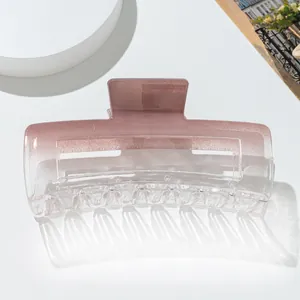 Detail of pink gradient large hair claw clip on a white pedestal for thick hair styling
