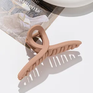 Détail de la pince à cheveux marron mat avec design torsadé et ressort élastique