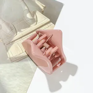 Detail of pink cat ear hair claw clip with glossy finish and metal spring mechanism