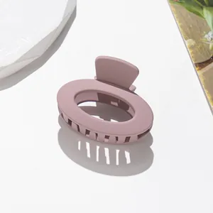 Dettaglio del piccolo fermaglio per capelli ovale opaco in rosa cipria satinato
