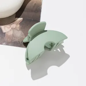 Detail of mint green matte finish mini hair claw clip with metal spring and arc design
