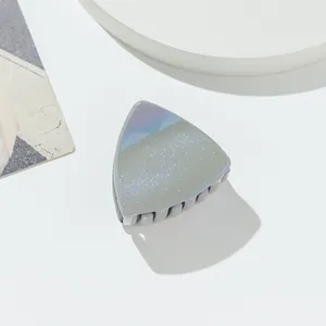 Macro shot of triangular glitter hair claw clip with holographic pearlescent finish