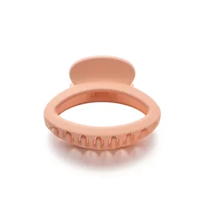 Matte peach oval hair claw clip with 10-tooth design for a secure minimalist hairstyle