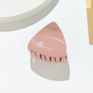 Detail of glitter cat ear hair claw clip with morandi pink finish on white pedestal