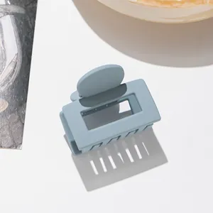 Vue détaillée d'une pince à cheveux carrée bleu brume mate avec poignée ronde