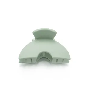 Macro detail of small matte mint green hair claw clip with strong metal spring