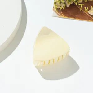 Detail view of triangular cream hair claw clip with fine glitter and smooth plastic finish