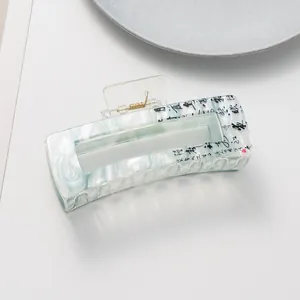 Detail of large acetate hair claw with green marble texture and Chinese calligraphy